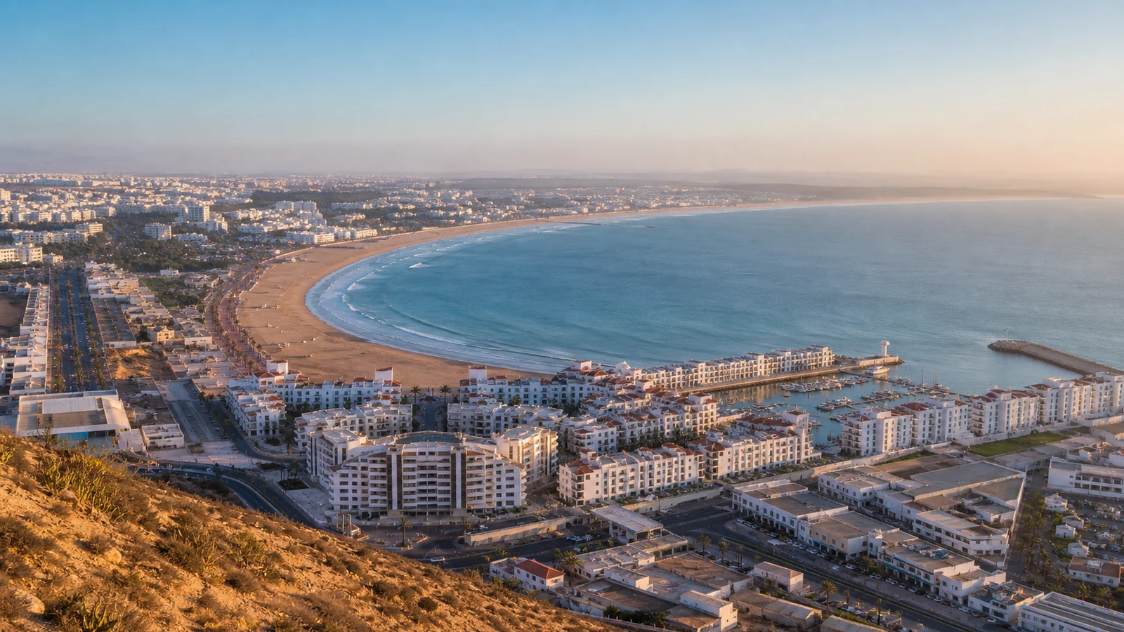 Panoramic morning view over Agadir city, marina and the curved Atlantic beach