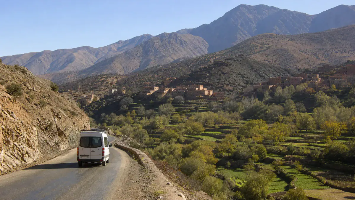 Minibus traveling through an Atlas Mountains valley on a day trip from Marrakech