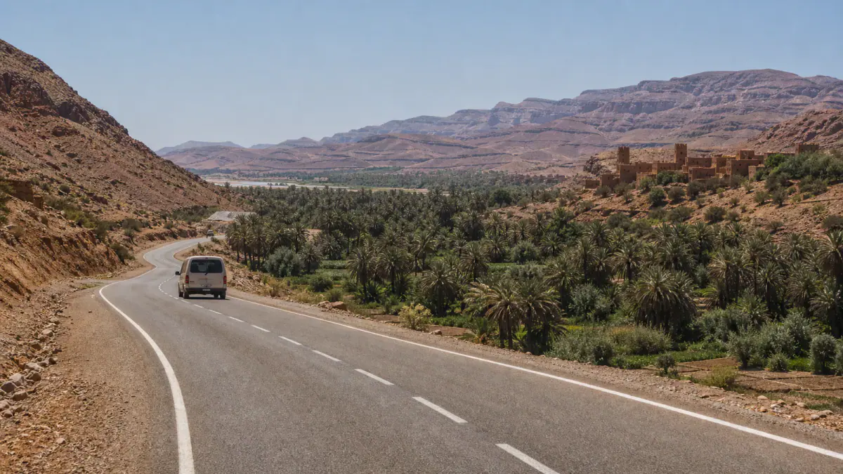 Road through a palm valley and dry mountains on a Morocco desert route