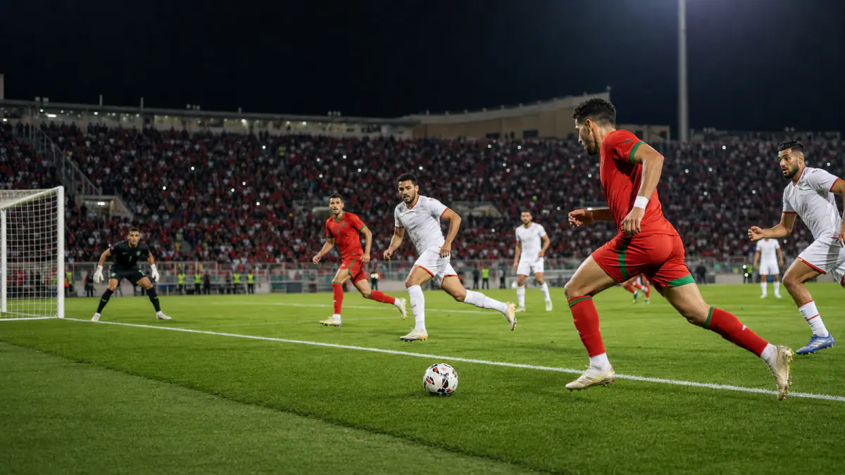 Anonymous Morocco and Tunisia football players contesting a night match in Fez