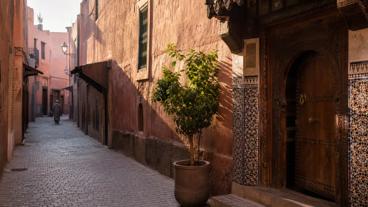 Quiet ochre lane and carved doorway in the Marrakech medina